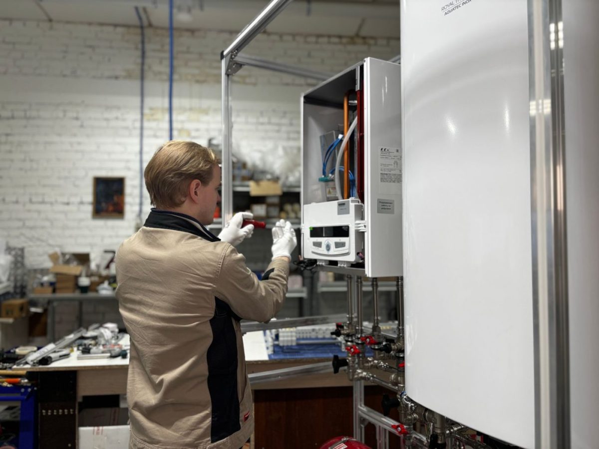 A person opens a built-in ice maker in a bright residential kitchen to check the ice production.
